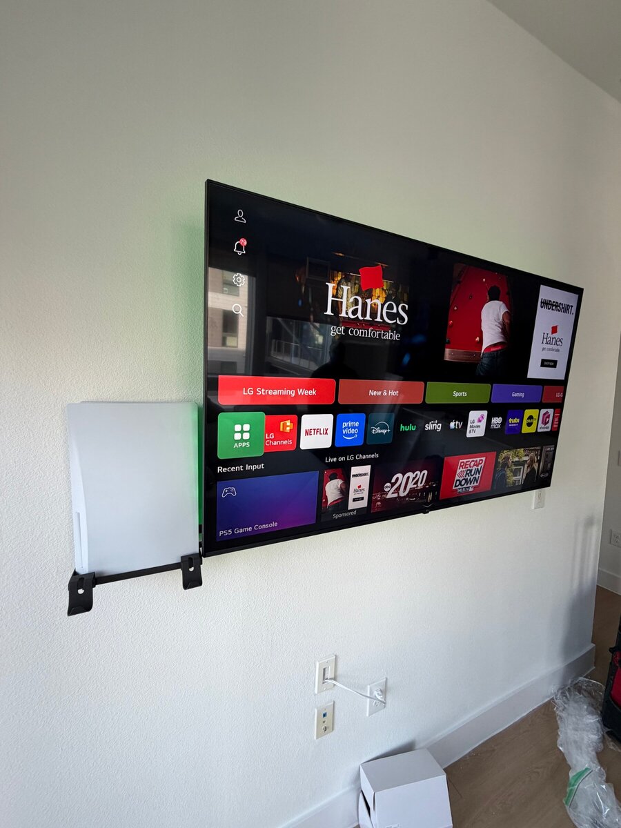 LG TV wall mount with PS5 console mounted on the wall beside it, Houston TX
