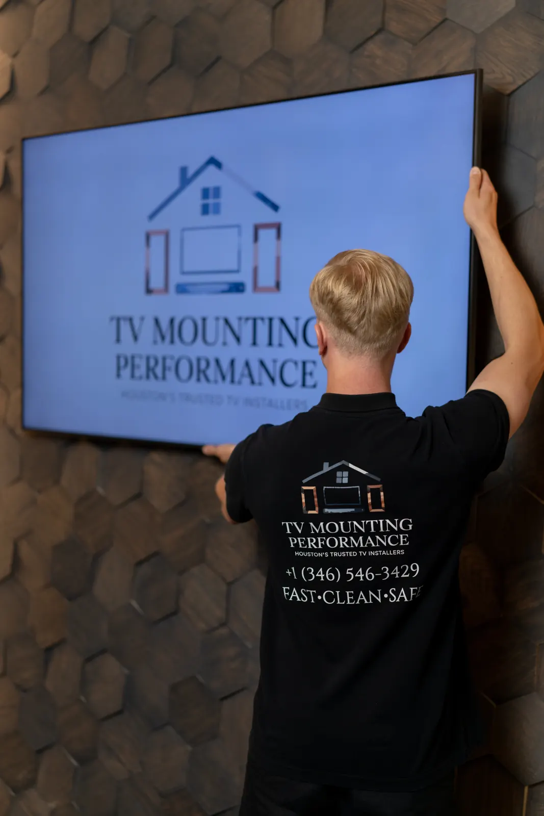 Technician mounting a TV on a wall