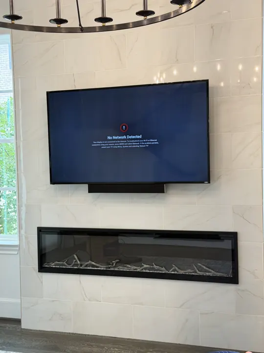 TV on a marble wall above a linear fireplace, Houston TX