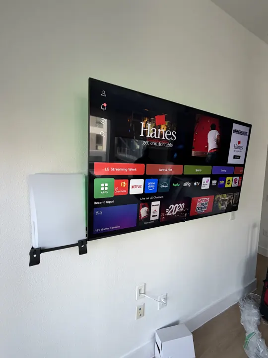 Gaming setup with PS5 mounted on the wall beside the TV, Houston TX